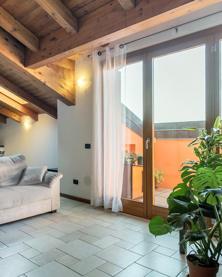 Il soggiorno dell'Alba a Ranica, con le travi a vista e la portafinestra sul terrazzo