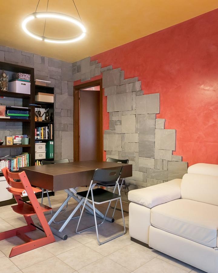 Il soggiorno del Rubino a Scanzorosciate, pareti rosse e libreria
